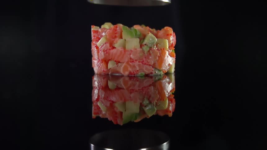 A person lifts a container off of food