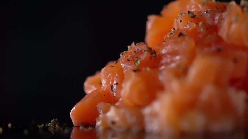 Seasoning being sprinkled on top of fish