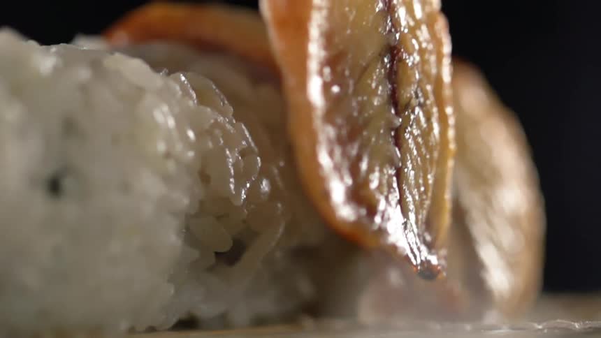 Fish being placed on top of sushi