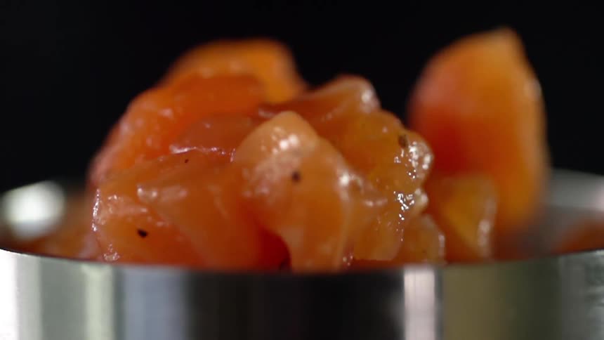 Raw meat drops into a metal cooking pan
