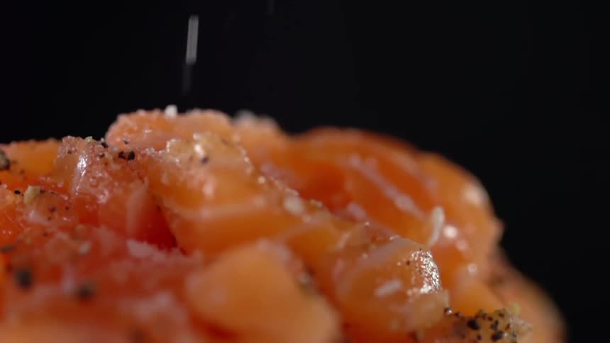 Spices fall on to the pile of orange food