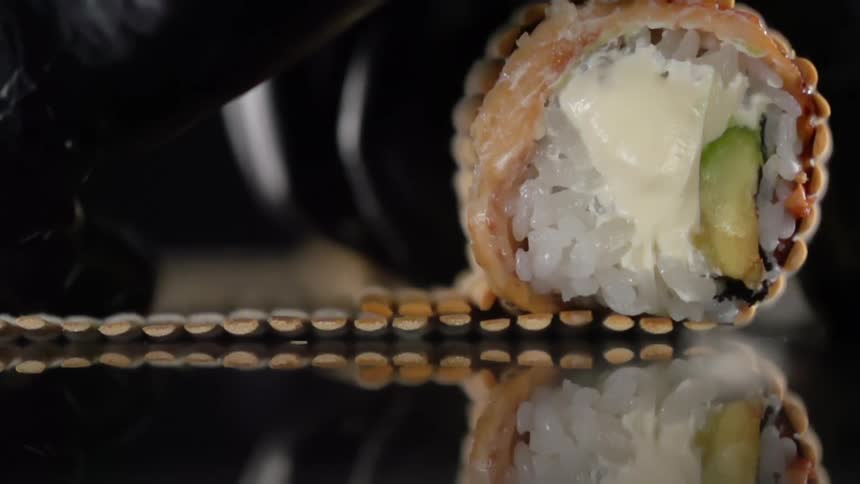 A person rolls a piece of sushi