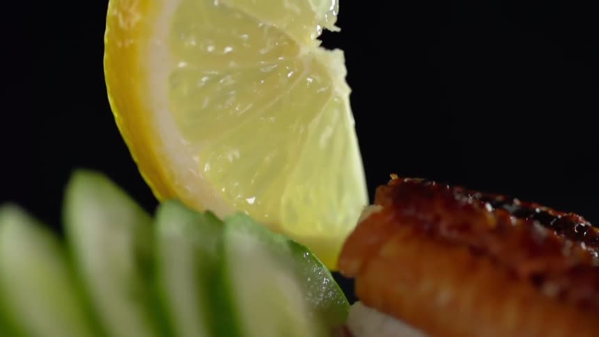A slice of lemon being placed among vegetables and other food