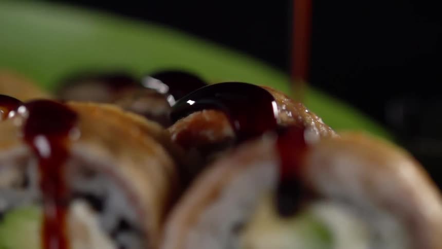 Dark thick sauce pour over sliced sushi rolls