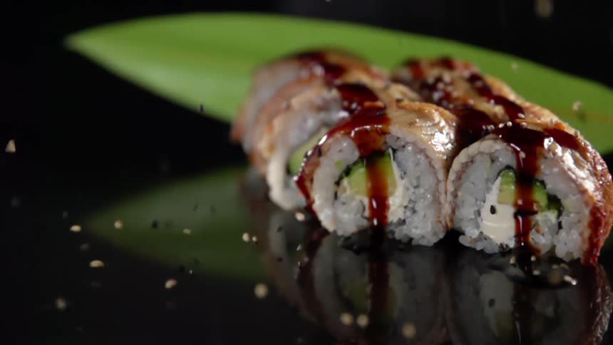Spices drop onto the food rolls and bounce on the plate