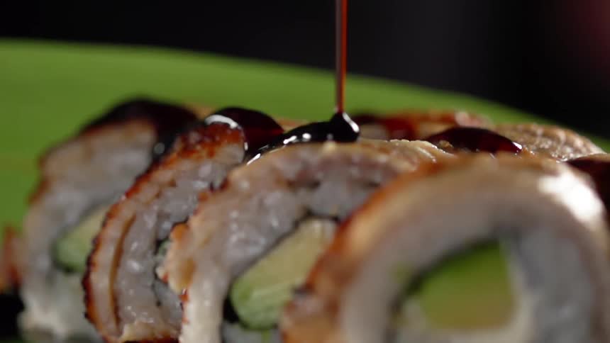 Sauce pouring over sushi rolls