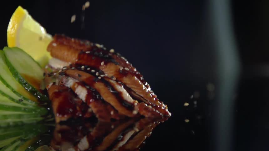 Sesame seeds being sprinkled on top of meat
