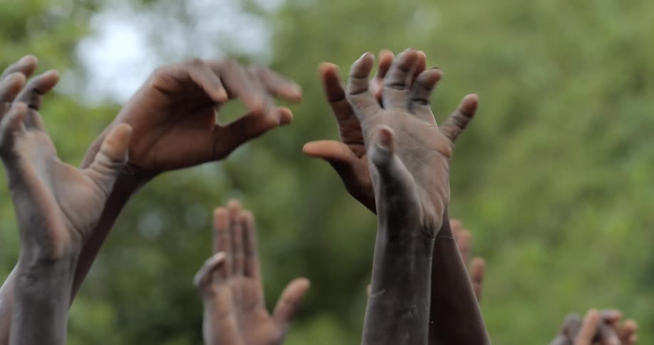 Close up of a group of hands waving in the air