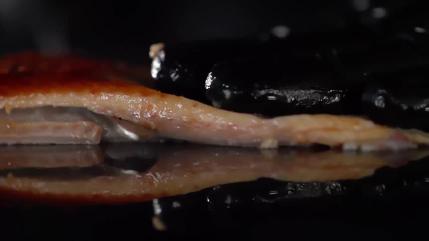 A knife cuts through a piece of meat
