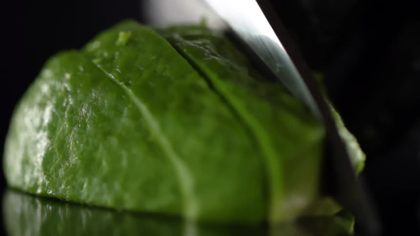 A knife is used to cut up an avocado