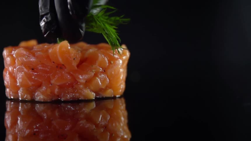 A person places garnish on sushi