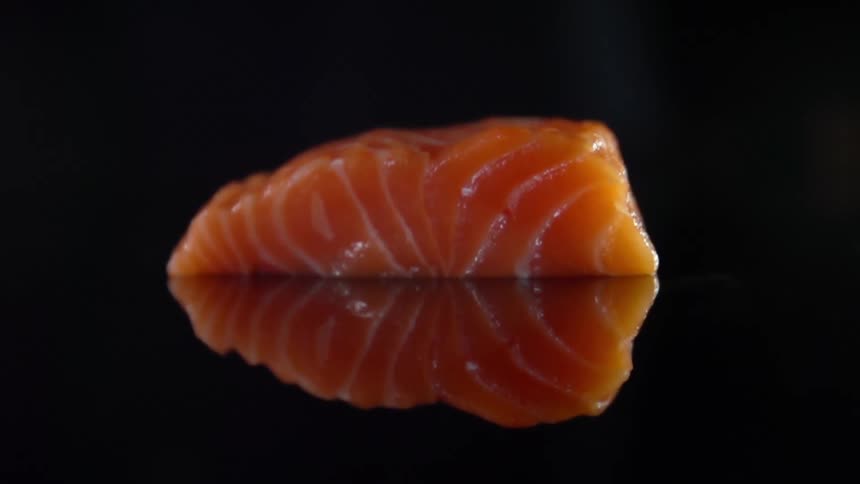 A piece of salmon falling on to a counter top
