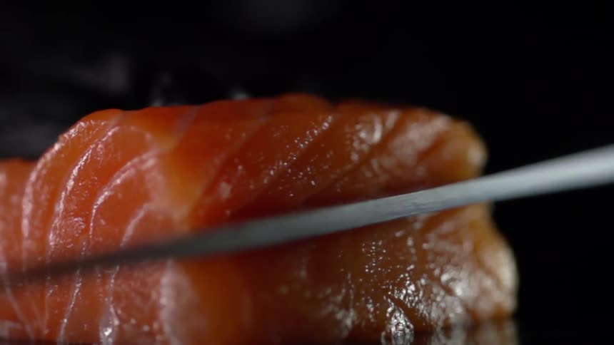 A piece of fish is being cut