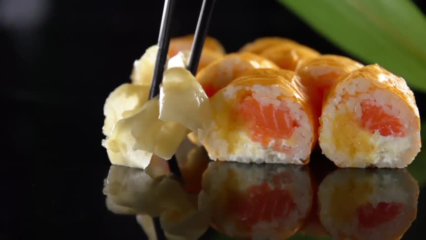 A small bunch of steamed cabbage is placed next to several pieces of sushi