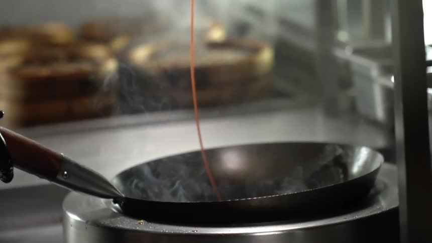 Sauce being poured in a circle around the inside of a steaming skillet