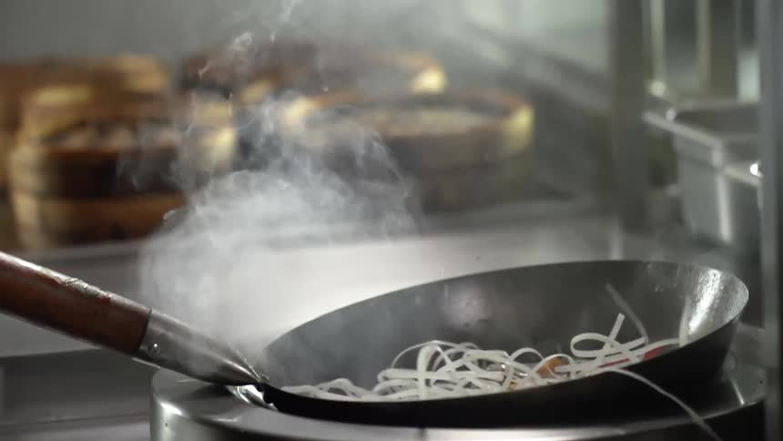 Noodles are dropped into a hot wok