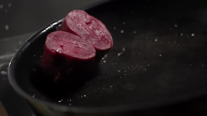 Raw beef medallions are cooked in a pan with oil