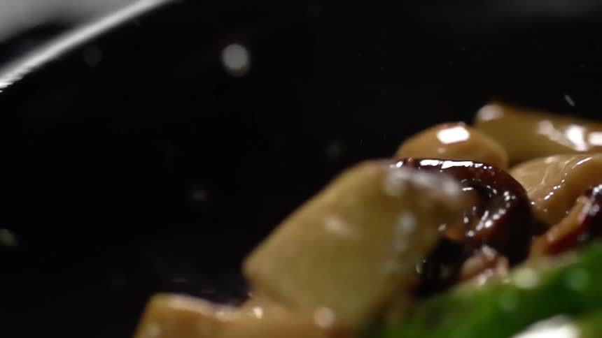 Mushrooms and bok choy bounce around in a wok