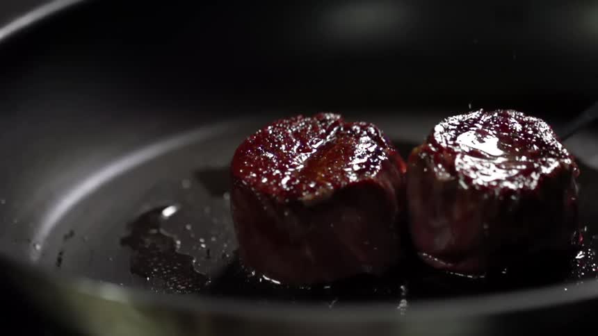 Beef medallions being cooked in a pan