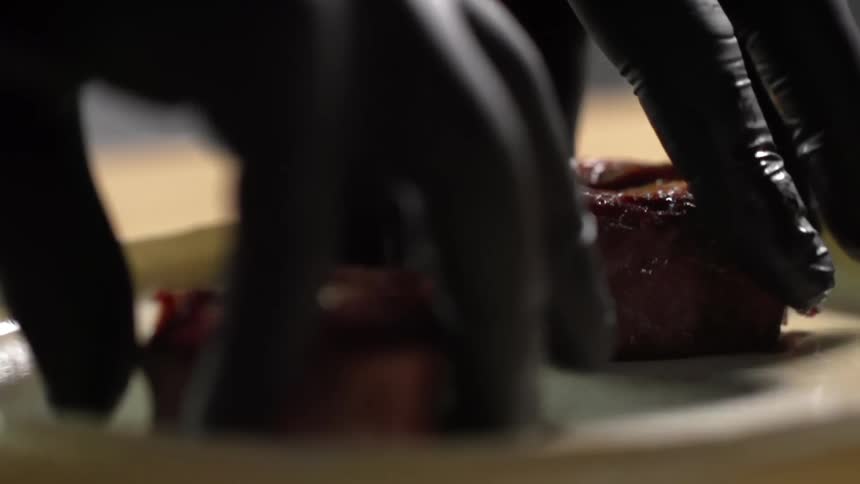 A person puts beef steaks on a plate