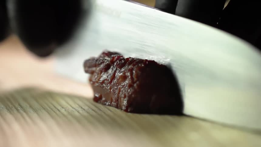 A person cuts a piece of beef