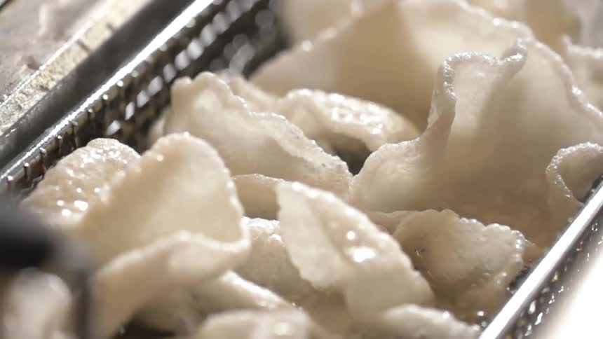 Shrimp chips being fried in a deep fryer