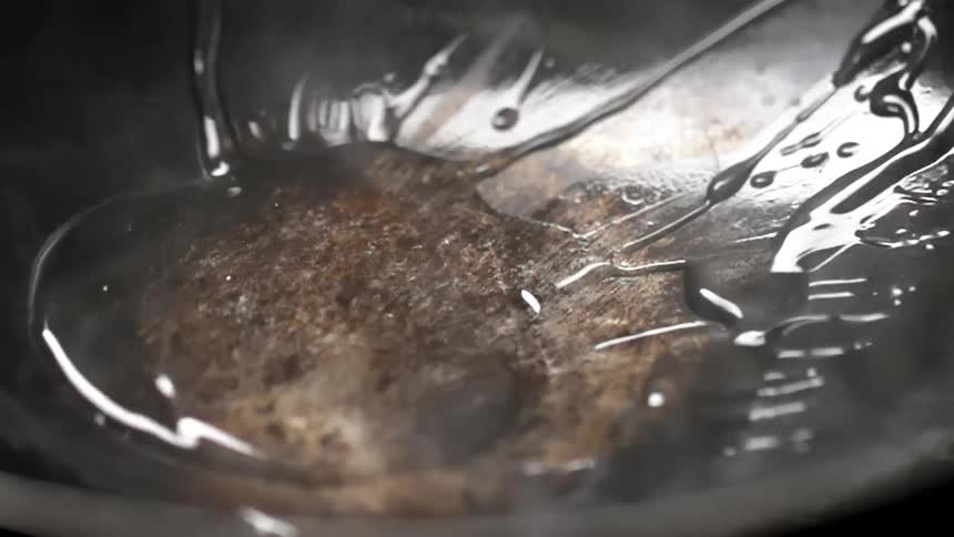 Oil pouring inside a steaming hot wok