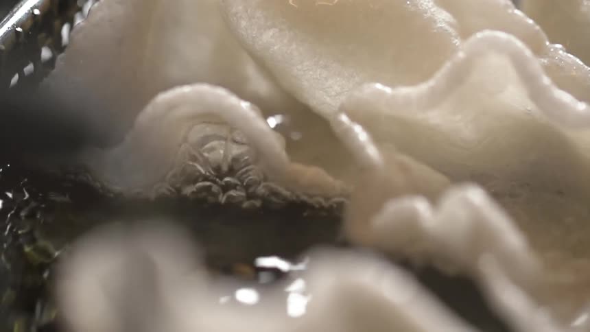 Shrimp chips being fried in a deep fryer