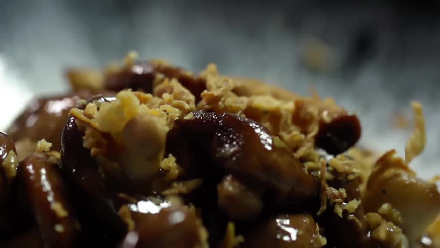 Crumbs falling over cooked meat inside a bowl
