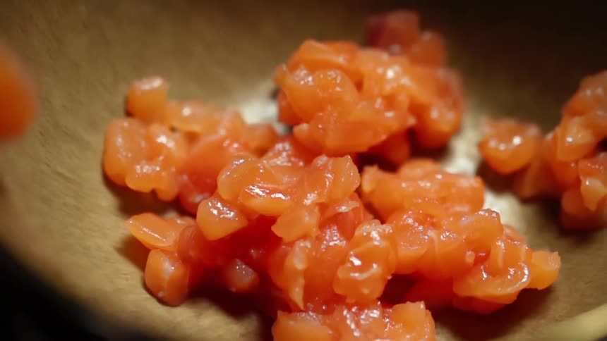 Finely cut salmon falling into a bowl