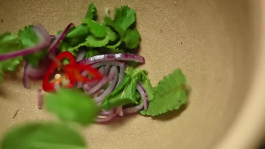 Sliced vegetables fall into a mortar