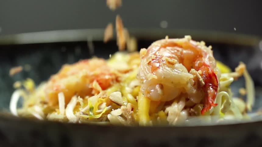 Crumb topping falls onto the grilled prawns