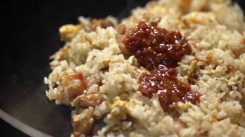 Homemade tomato sauce falling on rice inside a hot pan