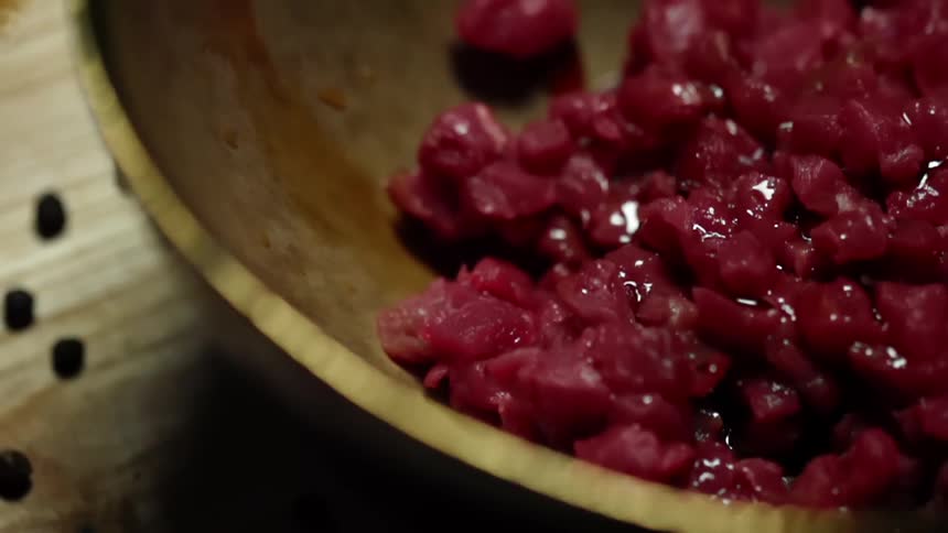 Soy sauce drips on tuna mince in a wooden bowl
