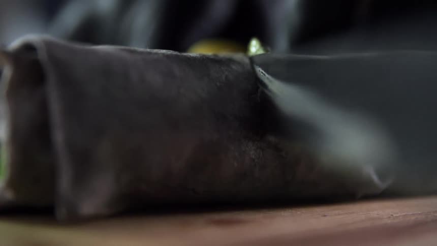 A person cuts a wrap in half