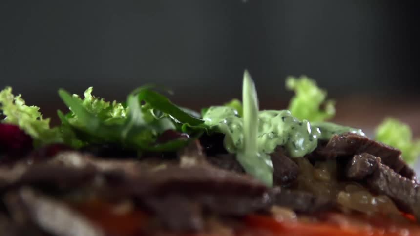 Green sauce is added to sliced steak