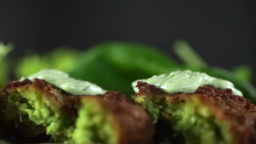 Green vegetarian meatballs showered in green sauce