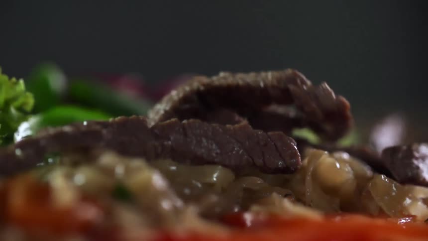Meat being dropped on to vegetables