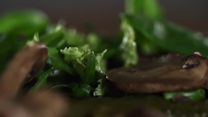 Mushrooms are dropped on a salad