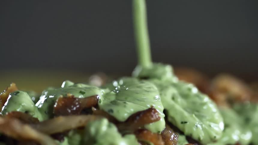 Guacamole dripping over finely chopped cooked pork