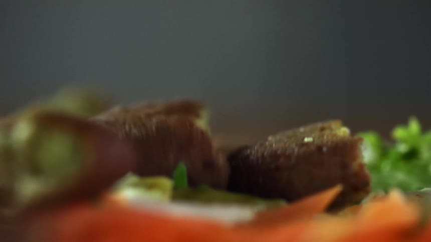 Cut up pieces of falafel are dropped onto a pita