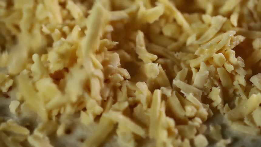 Cheese is sprinkled on a tortilla