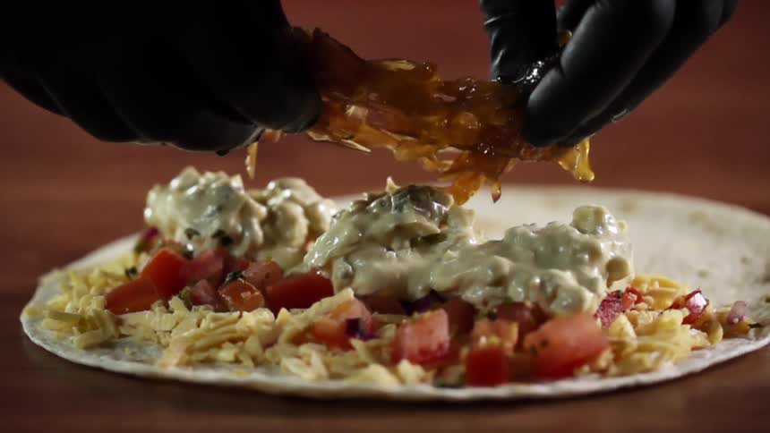 A person places the finishing touches on a meal