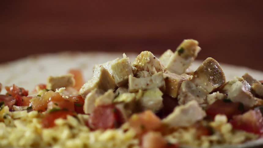 Cubes of chicken are dropped on the tortilla