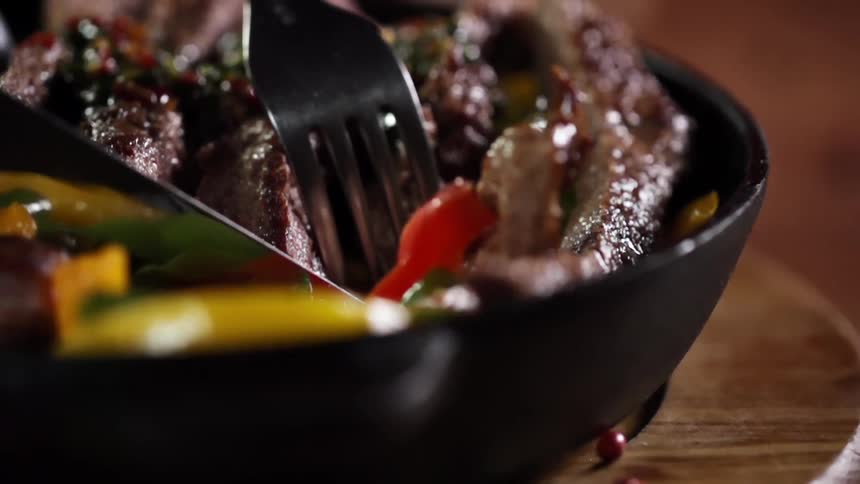 Meat in a bowl of food being cut