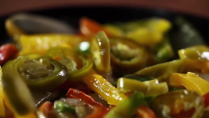 A bowl with vegetables with vegetables falling into the bowl