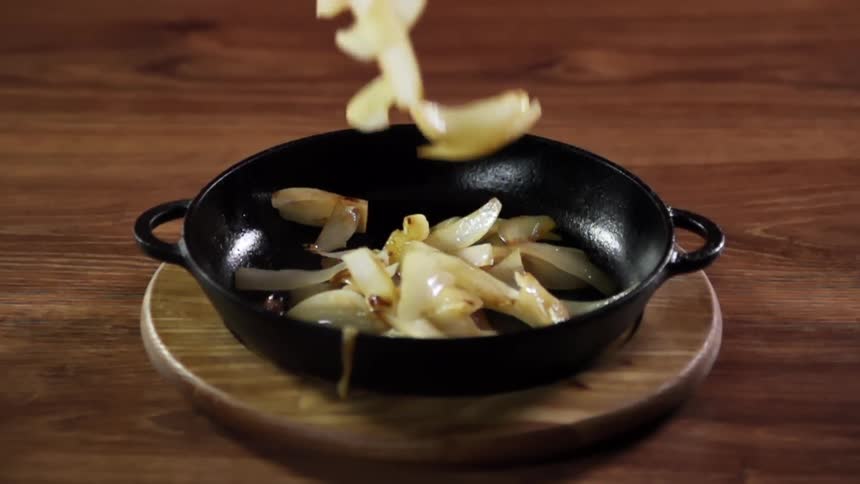 Onions falling in to a pan for a photo shoot