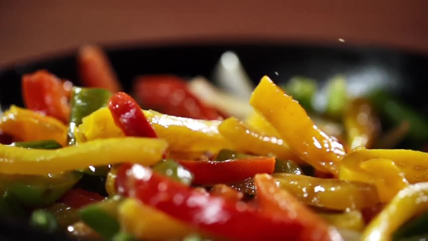 Pan roasted vegetables are being dropped into a black skillet