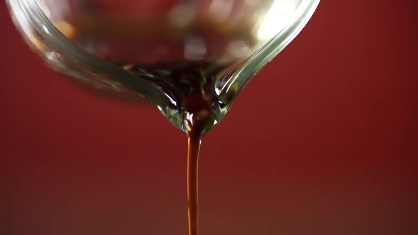 Sauce being poured out of a glass container