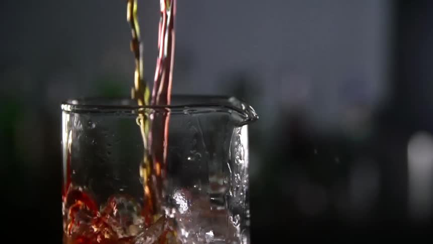 Cocktail is mixed into a glass jar with ice cubes
